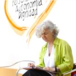 Lourdes Bermejo escribiendo junto a las palabras autonomía y dignidad.