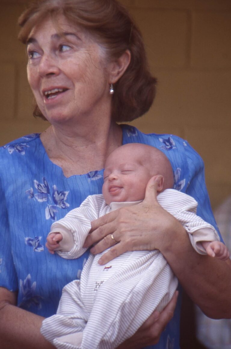 Mujer mayor sosteniendo a un bebé en brazos, reflejo de la calidad de vida basada en las relaciones, el cuidado y la continuidad entre generaciones.