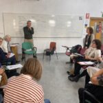 Personas mayores dialogando en el espacio común de una comunidad de cohousing sénior.
