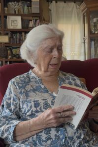Mujer de 95 años leyendo un libro en su casa